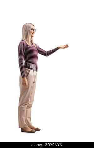 Foto di profilo a lunghezza intera di una giovane donna che si allarga il braccio in avanti e in attesa isolati su sfondo bianco Foto Stock
