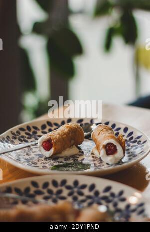 Dessert italiano Cannoli, cucina siciliana. Conchiglie dolci di pasta fritta farcita, farcite con ricotta dolce e cremosa, solitamente contenente ricotta Foto Stock