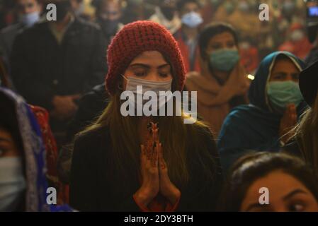 I cristiani pakistani adorano la messa di Natale di metà notte in vista delle celebrazioni natalizie nella Chiesa di Sant'Antonio a Lahore. Foto Stock