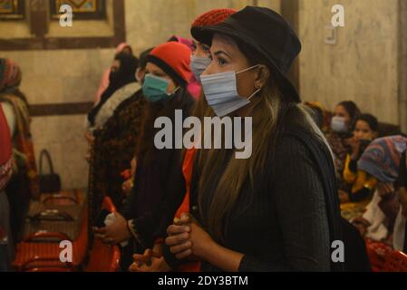 I cristiani pakistani adorano la messa di Natale di metà notte in vista delle celebrazioni natalizie nella Chiesa di Sant'Antonio a Lahore. Foto Stock