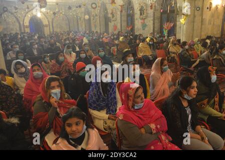 I cristiani pakistani adorano la messa di Natale di metà notte in vista delle celebrazioni natalizie nella Chiesa di Sant'Antonio a Lahore. Foto Stock