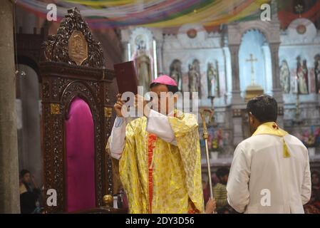 I cristiani pakistani adorano la messa di Natale di metà notte in vista delle celebrazioni natalizie nella Chiesa di Sant'Antonio a Lahore. Foto Stock