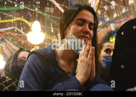 I cristiani pakistani adorano la messa di Natale di metà notte in vista delle celebrazioni natalizie nella Chiesa di Sant'Antonio a Lahore. Foto Stock