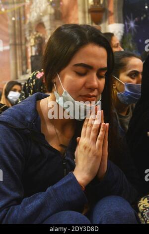 I cristiani pakistani adorano la messa di Natale di metà notte in vista delle celebrazioni natalizie nella Chiesa di Sant'Antonio a Lahore. Foto Stock