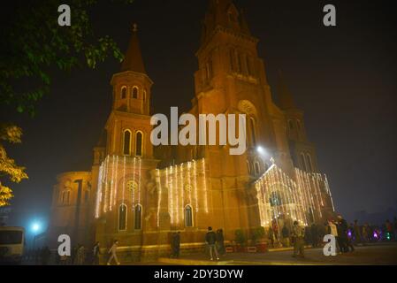 I cristiani pakistani adorano la messa di Natale di metà notte in vista delle celebrazioni natalizie nella Chiesa di Sant'Antonio a Lahore. Foto Stock