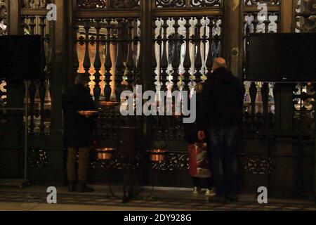 La cappella reale del Tesoro di San Gennaro è una cappella barocca della cattedrale di Napoli costruita per volontà dei napoletani per un voto a San Gennaro. È una delle più alte espressioni artistiche della città, sia per la concentrazione e il prestigio delle opere in essa contenute, sia per il numero di artisti di fama internazionale che hanno partecipato alla sua realizzazione. Le decorazioni pittoriche e affrescate dell'interno, eseguite principalmente da Domenichino e Lanfranco, fanno della cappella l'epicentro della pittura emiliana barocca di Napoli. Fedeli che pregano all'ingresso della Cappella reale del Tr Foto Stock