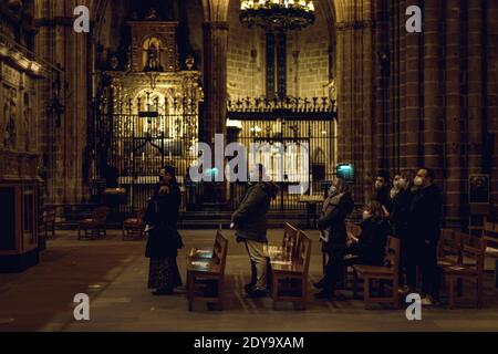 Barcellona, Spagna. 24 Dic 2020. I fedeli indossano maschere protettive per il viso, poiché partecipano a una congregazione della chiesa molto ridotta che celebra la Messa della vigilia di Natale sotto stretta misura igienica, a causa della continua diffusione del virus COVID-19 nella Cattedrale di Barcellona. Credit: Matthias Oesterle/Alamy Live News Foto Stock