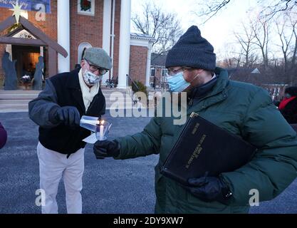 Ladue, Stati Uniti. 24 Dic 2020. I parrocchiani illuminano le candele, prima del servizio della vigilia di Natale fuori della Chiesa episcopale di San Pietro in Ladue, Missouri, giovedì 24 dicembre 2020. I membri hanno coraggiato il freddo di 21 gradi, per recitare le preghiere per circa 30 minuti. Photo by Bill Greenblatt/UPI Credit: UPI/Alamy Live News Foto Stock