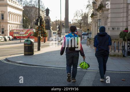 Londra, Regno Unito. 24 Dic 2020. Persone che camminano lungo una strada vuota e deserta in Lower Regent Street durante la vigilia di Natale 2020. Credit: SOPA Images Limited/Alamy Live News Foto Stock