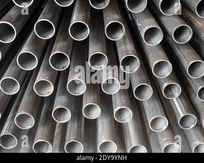 Tubi in acciaio inox sporchi che fuoriescono da un rack. Foto Stock