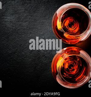 Due bicchieri di brandy su sfondo di pietra nera, vista dall'alto Foto Stock