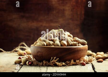 Arachidi in conchiglia, sfondo in legno vintage, fuoco selettivo Foto Stock