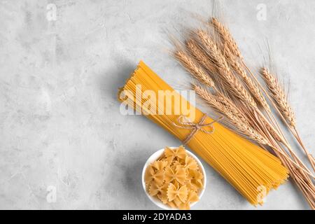 Pasta e gancetti di grano su fondo grigio in cemento. Foto Stock