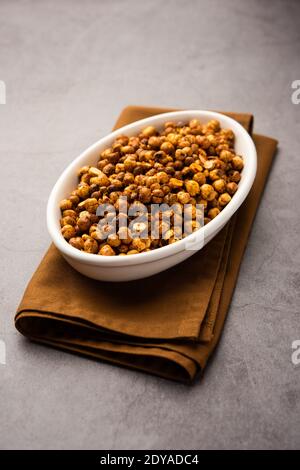 Piccante croccante ceci arrostiti o fritti o futana con paprika, fuoco selettivo. Gustoso e popolare spuntino vegetariano o contorno o chakna consumati con c Foto Stock