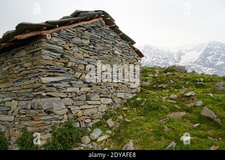 Case rocciose realizzate per rifugi in montagna per pastori. Triund Hill, Himalaya Mountains, Himachal, Pradesh, India Foto Stock