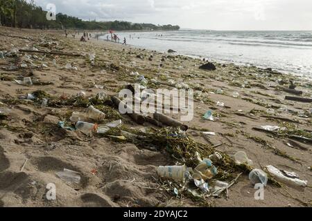 Le materie plastiche e i trash organici tagliano la linea costiera della famosa spiaggia di Bali Kuta. Tonnellate di Trash, secondo quanto riferito, scaricati nei fiumi dai cittadini, e trasportati sulla spiaggia durante la stagione delle piogge. Foto Stock