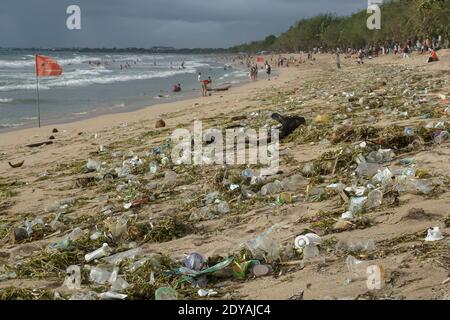 Le materie plastiche e i trash organici tagliano la linea costiera della famosa spiaggia di Bali Kuta. Tonnellate di Trash, secondo quanto riferito, scaricati nei fiumi dai cittadini, e trasportati sulla spiaggia durante la stagione delle piogge. Foto Stock