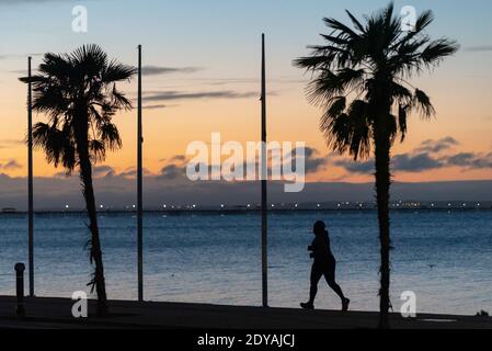 Southend on Sea, Essex, Regno Unito. 25 Dic 2020. Il giorno di Natale a Southend è freddo ma luminoso, con temperature appena sopra il congelamento. I joggers stanno funzionando lungo le promenades prima dell'alba per il loro esercitazione di COVID di Tier 4 19 Foto Stock
