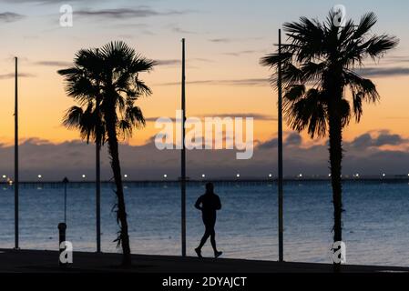 Southend on Sea, Essex, Regno Unito. 25 Dic 2020. Il giorno di Natale a Southend è freddo ma luminoso, con temperature appena sopra il congelamento. I joggers stanno funzionando lungo le promenades prima dell'alba per il loro esercitazione di COVID di Tier 4 19 Foto Stock