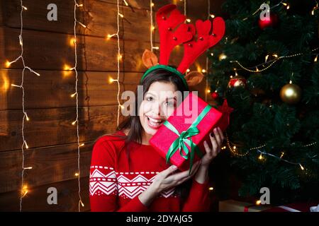 felice giovane donna in oro bellissimo albero di natale con luci Foto Stock