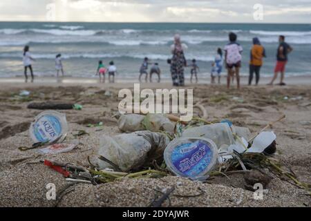 Badung, Bali, Indonesia. 20 dicembre 2020. I turisti sono visti lungo la spiaggia tra le trashes.tons di Trash riferito scaricato nei fiumi dai cittadini, e trasportato sulla spiaggia durante la stagione delle piogge. Credit: Dicky Bisinglasi/SOPA Images/ZUMA Wire/Alamy Live News Foto Stock