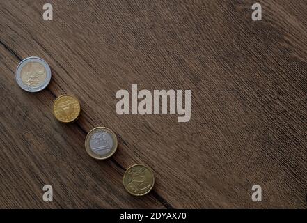 Monete in euro impilate sullo sfondo di un tavolo di legno Foto Stock