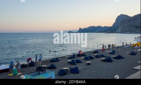 21 luglio 2017, Sudak. I vacanzieri in una calda serata sulla spiaggia della città di Sudak. Foto Stock