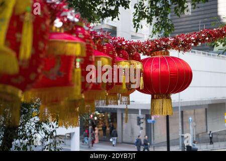 Belle lanterne cinesi impiccate nelle strade di Hong Kong. Decorazioni colorate in oro e rosso. Luce del giorno. Foto Stock