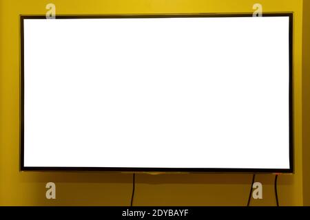 Moderno televisore widescreen con schermo vuoto appeso alla parete, mockup, moderno pannello video nero a schermo piatto. Foto Stock