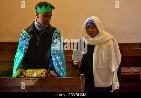 I devoti cristiani pregano all'interno della Chiesa Cattolica della Sacra Famiglia durante il Natale. Foto Stock