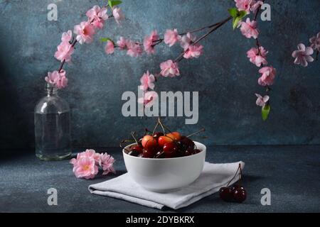 Ciliegie dolci rosse e gialle in una ciotola di ceramica bianca. Dolce estivo Foto Stock