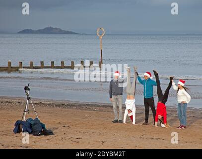 Portobello, Edimburgo, Scozia, Regno Unito. 25 dicembre 2020. Nuvoloso con una temperatura di 3 gradi per questi slovacchi indossare cappelli Santa che vivono in una bolla sociale in città e stanno celebrando il giorno di Natale al mare in quanto non hanno potuto viaggiare a casa a causa delle restrizioni di viaggio Covid-19. Credit: Arch White/Alamy Live News. Foto Stock