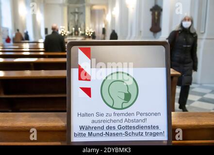 Dresda, Germania. 25 Dic 2020. Con un piccolo numero di fedeli, che hanno dovuto iscriversi a questo servizio in anticipo, i visitatori celebrano l'alta Messa di Natale nella Cattedrale di Dresda il giorno di Natale. Credit: Matthias Rietschel/dpa-Zentralbild/dpa/Alamy Live News Foto Stock