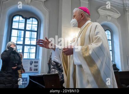 Dresda, Germania. 25 Dic 2020. Il Vescovo Heinrich Timmerevers celebra l'alta Messa di Natale nella Cattedrale di Dresda il giorno di Natale con un piccolo numero di fedeli che hanno dovuto iscriversi in anticipo a questo servizio. Credit: Matthias Rietschel/dpa-Zentralbild/dpa/Alamy Live News Foto Stock