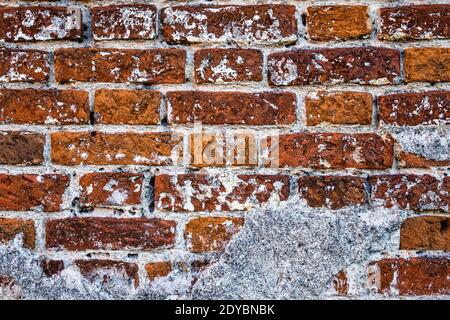 Primo piano di un muro fatto di vecchio mattone e spaccato intonaco Foto Stock