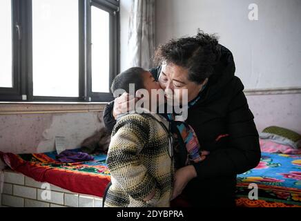 (201225) -- YINCHUAN, 25 dicembre 2020 (Xinhua) -- UN ragazzo bacia Ding Haiyan nel villaggio di Hejiayuan di Xihaigu nella regione Autonoma di Ningxia Hui nella Cina nord-occidentale, 28 ottobre 2020. Xihaigu, una regione in gran parte montagnosa nel nord-ovest del Ningxia, è stata un tempo inflitta dalla profonda povertà ed è stata identificata come il "più inadatto luogo di insediamento umano" dalle Nazioni Unite negli anni '70 a causa della bonifica del territorio, della siccità e di un fragile ambiente ecologico. Il 16 novembre 2020, Xyhaigu storicamente si è addio alla povertà assoluta, durante la quale il 'potere' ha svolto un ruolo indispensabile. Ding Haiyan, 55 anni, è presidente del trad Foto Stock