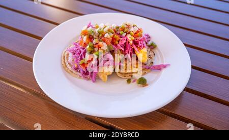 Red Snapper Fish Tacos su piatto bianco e tavolo in legno Foto Stock