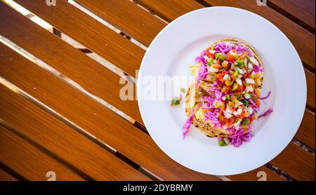 Red Snapper Fish Tacos su piatto bianco e tavolo in legno Foto Stock