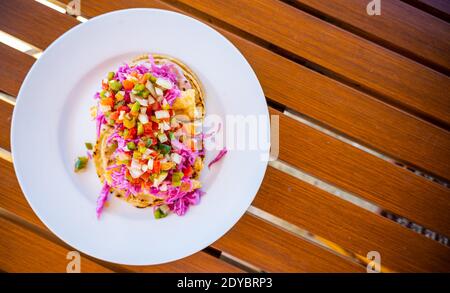 Red Snapper Fish Tacos su piatto bianco e tavolo in legno Foto Stock