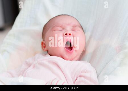 Chinese baby girl nove settimane di sonno con un grande yawn. Nessun dente ancora. Foto Stock