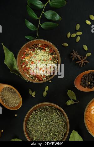 Ampia varietà di spezie ed erbe sullo sfondo del tavolo nero Foto di alta qualità Foto Stock