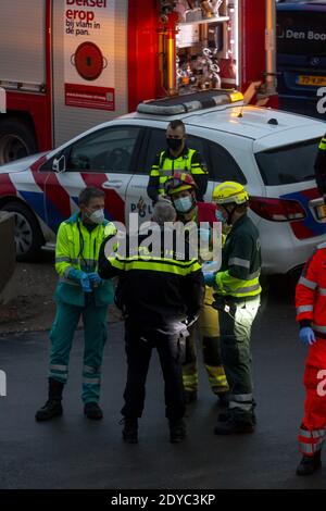 ZUTPHEN, PAESI BASSI - 08 dicembre 2020: Task force di personale di ambulanza, polizia e vigili del fuoco in maschere di faccia che deliberano e organizzano ad un accid Foto Stock