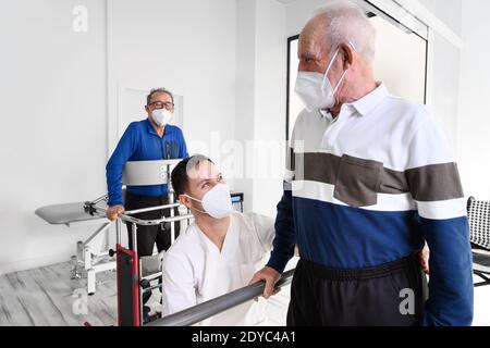 Gruppo di fisioterapisti che lavorano nel centro di riabilitazione, aiutando i pazienti. Foto di alta qualità Foto Stock