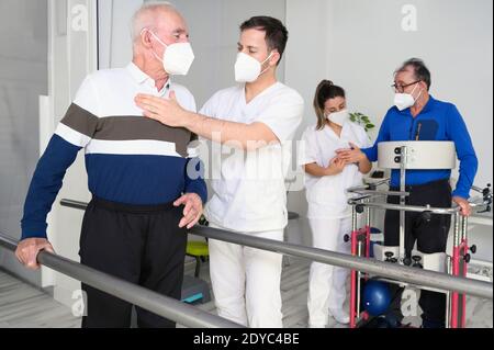 Gruppo di fisioterapisti che lavorano nel centro di riabilitazione, aiutando i pazienti. Foto di alta qualità Foto Stock