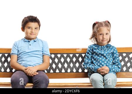 Ragazzo carino e una ragazza timida seduta su una panchina e guardando la telecamera isolata su sfondo bianco Foto Stock