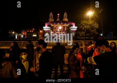 Nuova Delhi, India. 25 Dic 2020. Persone al di fuori della barricata della Cattedrale del Sacro cuore in occasione delle celebrazioni natalizie, tra la diffusione della malattia del coronavirus (COVID-19), a Nuova Delhi il 25 dicembre 2020. La più grande chiesa di Delhi, la Cattedrale del Sacro cuore, è stata rinchiusa il Natale per la prima volta a seguito del coronavirus. Credit: David Talukdar/ZUMA Wire/Alamy Live News Foto Stock