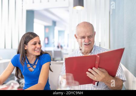 L'uomo maturo e la giovane donna si divertono e sorridono, trascorrendo il tempo insieme Foto Stock