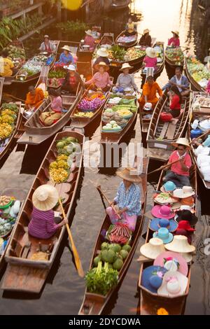Fornitori non identificati e turisti danno elemosina ai monaci a causa del buddismo a Khlong Damnoen Saduak, un famoso vecchio mercato galleggiante popolare in Thailandia. Foto Stock