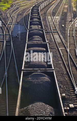 il carbone nero nei vagoni dei treni sulle rotaie viene spostato al successivo punto di scarico nella logistica Foto Stock