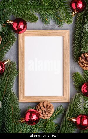 Natale vacanze composizione con immagine mockup cornice. Baubles rossi e rami di abete. Foto Stock